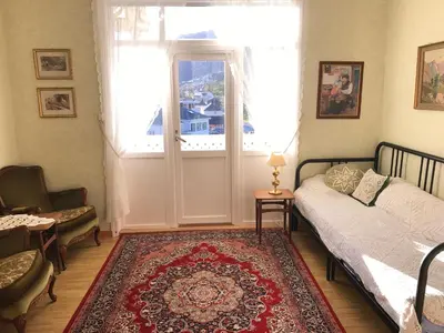 a bedroom with a bed and a window and a rug at Villa Holmen in Balestrand
