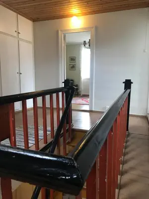 a staircase in a living room with a wooden railing at Villa Holmen in Balestrand