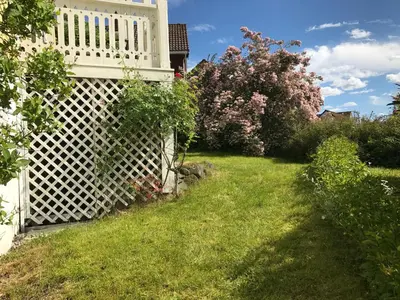 a garden with a white fence in the grass at Villa Holmen in Balestrand