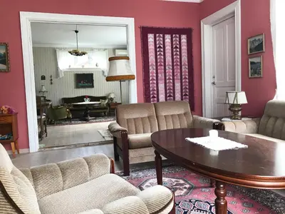a living room with pink walls and a table and chairs at Villa Holmen in Balestrand
