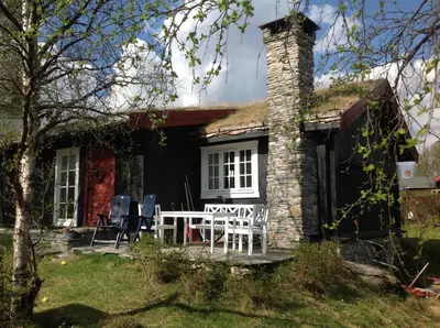 a house with a chimney and a table and chairs at Svenskveien 23b in Røros