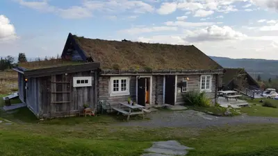 a small wooden house with a grass roof at Skei Apartments in Svingvoll