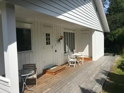 a wooden deck with a table and chairs on a house at Villa Holmen 2 in Balestrand