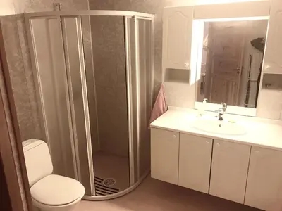 a bathroom with a shower and a toilet and a sink at Villa Holmen, ground floor apartment in Balestrand