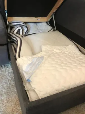 a bed with a white mattress in a room at Villa Holmen, ground floor apartment in Balestrand