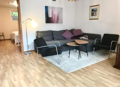 a living room with a couch and chairs and a table at Villa Holmen, ground floor apartment in Balestrand