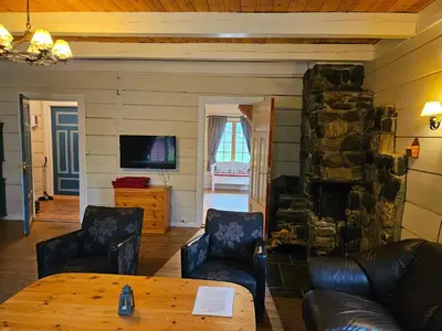 a living room with a couch and a stone fireplace at Trollbu Aabrekk gard in Briksdalsbre
