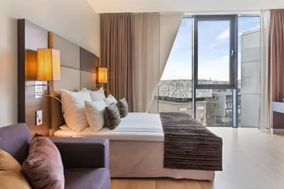 a hotel room with a bed and a large window at Clarion Hotel Trondheim in Trondheim