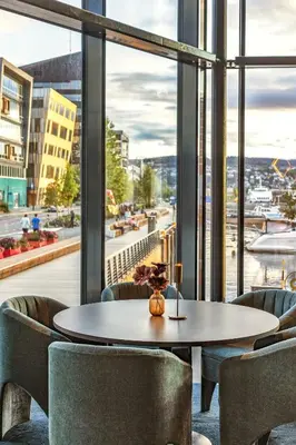 a table and chairs in a room with a large window at Clarion Hotel Trondheim in Trondheim