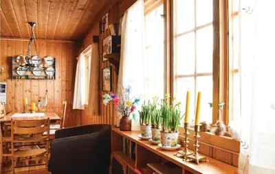 a dining room with a table and a large window at Stunning Home In Sjusjøen With Kitchen in Sjusjøen