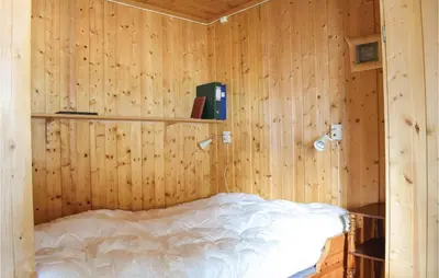 a bedroom with a bed in a wooden wall at Stunning Home In Sjusjøen With Kitchen in Sjusjøen