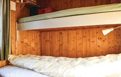 a room with two bunk beds in a wooden wall at Stunning Home In Sjusjøen With Kitchen in Sjusjøen