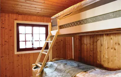 a bedroom with bunk beds in a wooden room at Cozy Home In Sjusjøen With Kitchen in Sjusjøen