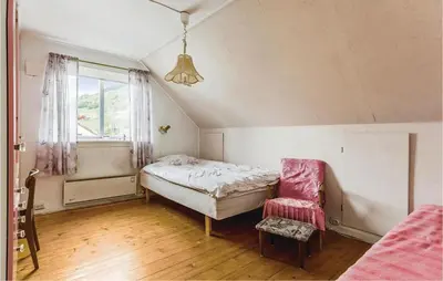 a bedroom with a bed and a chair and a window at 5 Bedroom Lovely Home In Seim in Seim