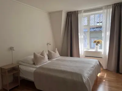 a white bedroom with a bed and a window at Blue House Odda in Odda