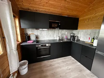 a kitchen with black cabinets and a counter top at Faleide Panorama Private Fjord View Cabin with Large Terrace in Stryn