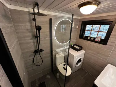 a bathroom with a shower with a toilet and a sink at Faleide Panorama Private Fjord View Cabin with Large Terrace in Stryn