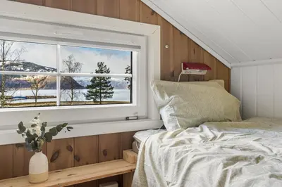 a bedroom with a bed and a window at Mikkelparken Ferietun in Kinsarvik
