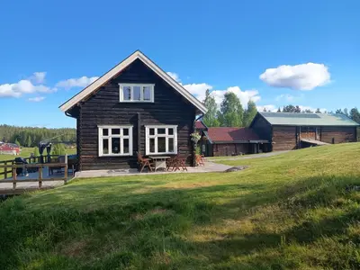 a small wooden house on a grassy field at Presterudveien 125 in Vikersund
