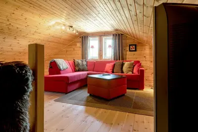 a living room with a red couch and a table at Valley View in Stranda