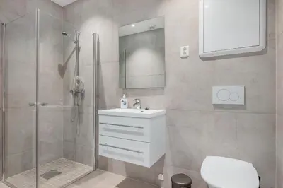 a bathroom with a shower and a sink and a toilet at NG Apartments in Bergen