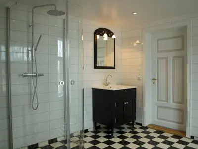 a bathroom with a sink and a shower with a mirror at Kårstua - Austrått Agroturisme in Austrått