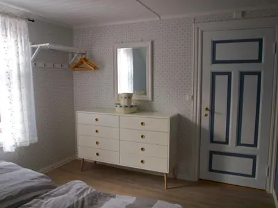 a bedroom with a bed and a dresser with a mirror at Kårstua - Austrått Agroturisme in Austrått