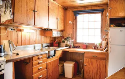 a kitchen with wooden cabinets and a white refrigerator at 5 Bedroom Stunning Home In Noresund in Noresund
