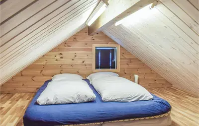 a bed with two pillows in a room at Four-Bedroom Holiday Home In Roldal in Røldal
