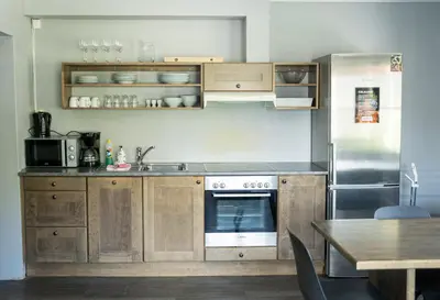 a kitchen with wooden cabinets and a stainless steel refrigerator at Hemsedal Cafe Skiers Lodge in Hemsedal