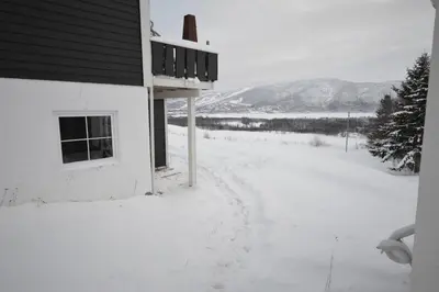 a snow covered road next to a house with a window at Apartment between Ustaoset and Geilo in Geilo