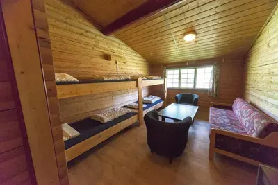 a room with two bunk beds in a log cabin at Dombås Hostel in Dombås