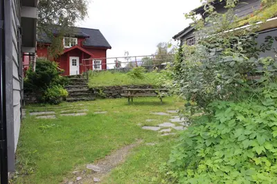 a garden with a bench in front of a house at Røldalstunet Overnatting in Røldal