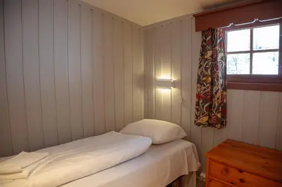 a small room with a bed and a window at Hunderfossen Cottages in Hafjell