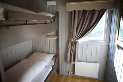 a small room with two bunk beds and a window at Hunderfossen Cottages in Hafjell