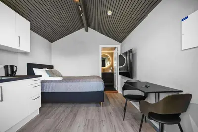 a bedroom with a bed and a table and chairs at Nordica Resort Florø in Florø