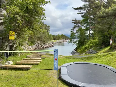 a basketball hoop next to a river with a sign at Nordica Resort Florø in Florø