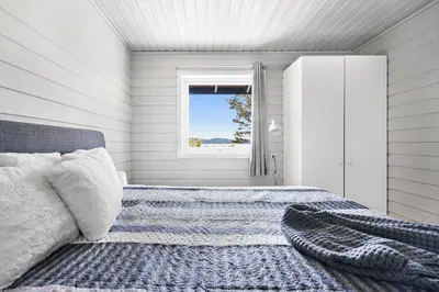 a bedroom with a bed and a window at Nordica Resort Florø in Florø