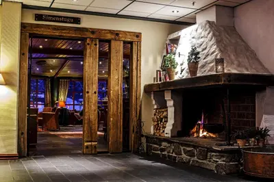 a lobby with a stone fireplace in a building at Hunderfossen Apartments in Hafjell
