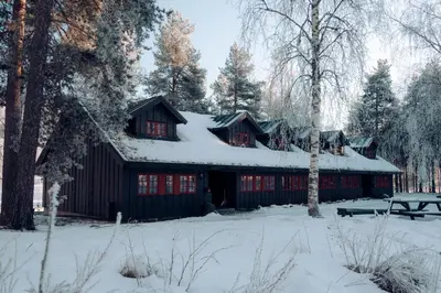 a black barn with snow on the roof at Hunderfossen Apartments in Hafjell