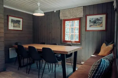 a dining room with a wooden table and chairs at Hunderfossen Apartments in Hafjell