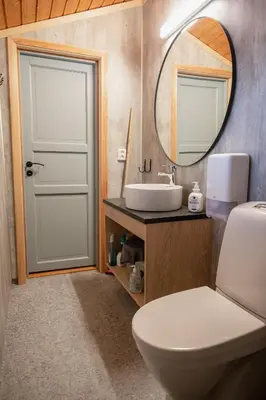 a bathroom with a white toilet and a mirror at Hytter Dombås in Dombås