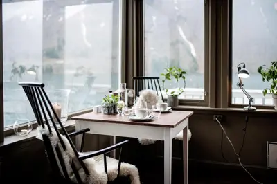 a table and chairs in a room with a window at Fjærland Fjordstove Hotell - Huseby Hotelldrift AS in Fjarland