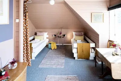 a attic room with two couches and a table at Fjærland Fjordstove Hotell - Huseby Hotelldrift AS in Fjarland