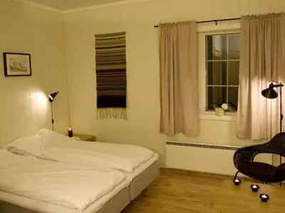 a bedroom with a bed and a chair and a window at Vassbakken Kro og Camping in Skjolden
