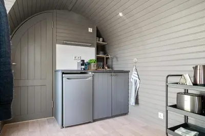 a kitchen with a gray refrigerator and an archway at Konglehytta 1 - 30 min fra OSL - Badstu - Utsikt - Romantikk in Strandlykkja