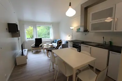 a kitchen and living room with a table and chairs at Trolltunga Camping in Odda