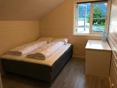 a bed in a room with a window at Loftesnes in Sogndal