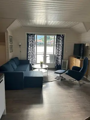 a living room with a blue couch and a table at Loftesnes in Sogndal