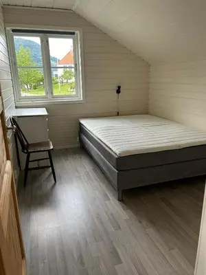 a bedroom with a bed and a chair in it at Loftesnes in Sogndal